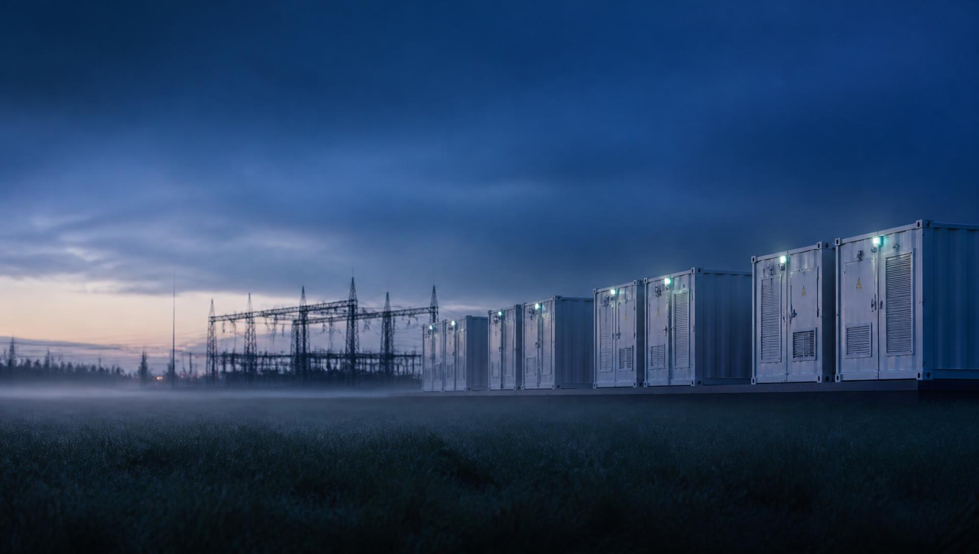 Batteriespeicher-Container und Umspannwerk in der Dämmerung